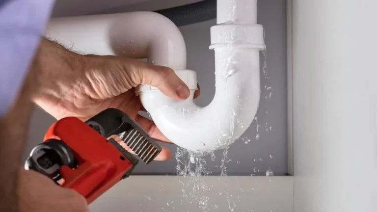 Emergency plumber fixing a leaking pipe under a sink – Leopold plumber