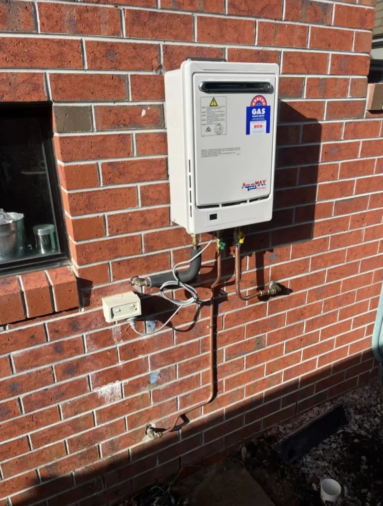 Gas continuous flow hot water unit installed on a brick wall
