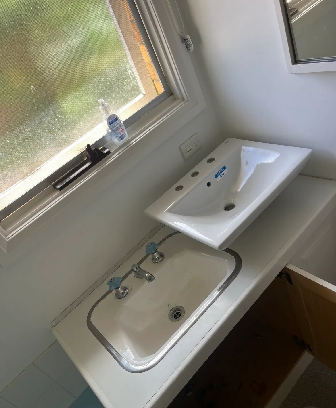 Old inset vanity basin with its replacement basin ready to fit