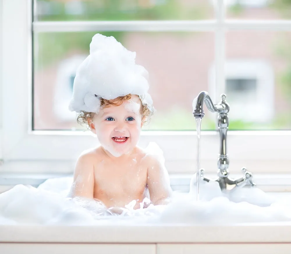 child in bath running hot water