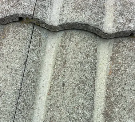 Close-up of a concrete roof tile with a hairline crack