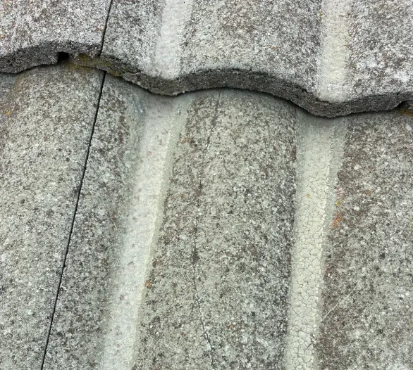 Close-up of a concrete roof tile with a hairline crack