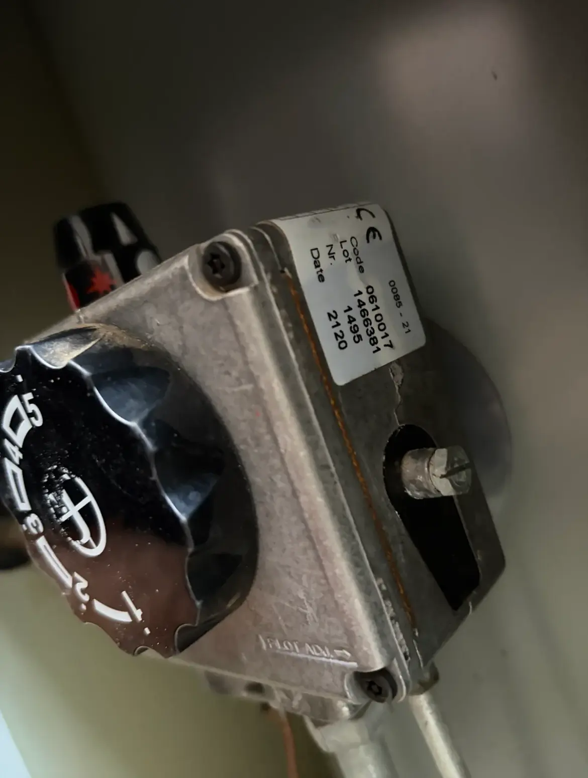 Close-up of a gas thermostat control knob and valve body