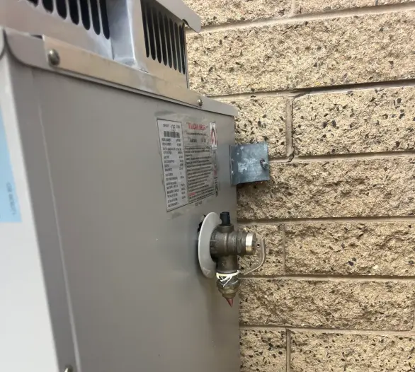 Close view of a pressure relief valve and the data plate on a hot water unit