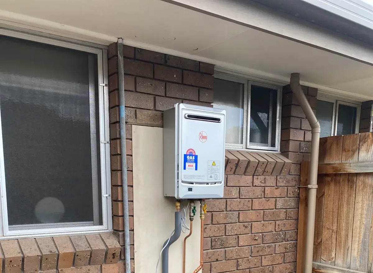 Continuous flow hot water unit on a brick wall with tidy copper pipework