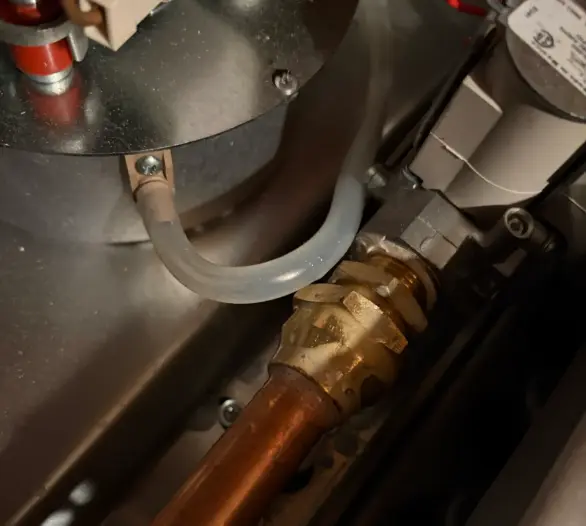 Copper pipe and brass fitting inside a gas heater cabinet