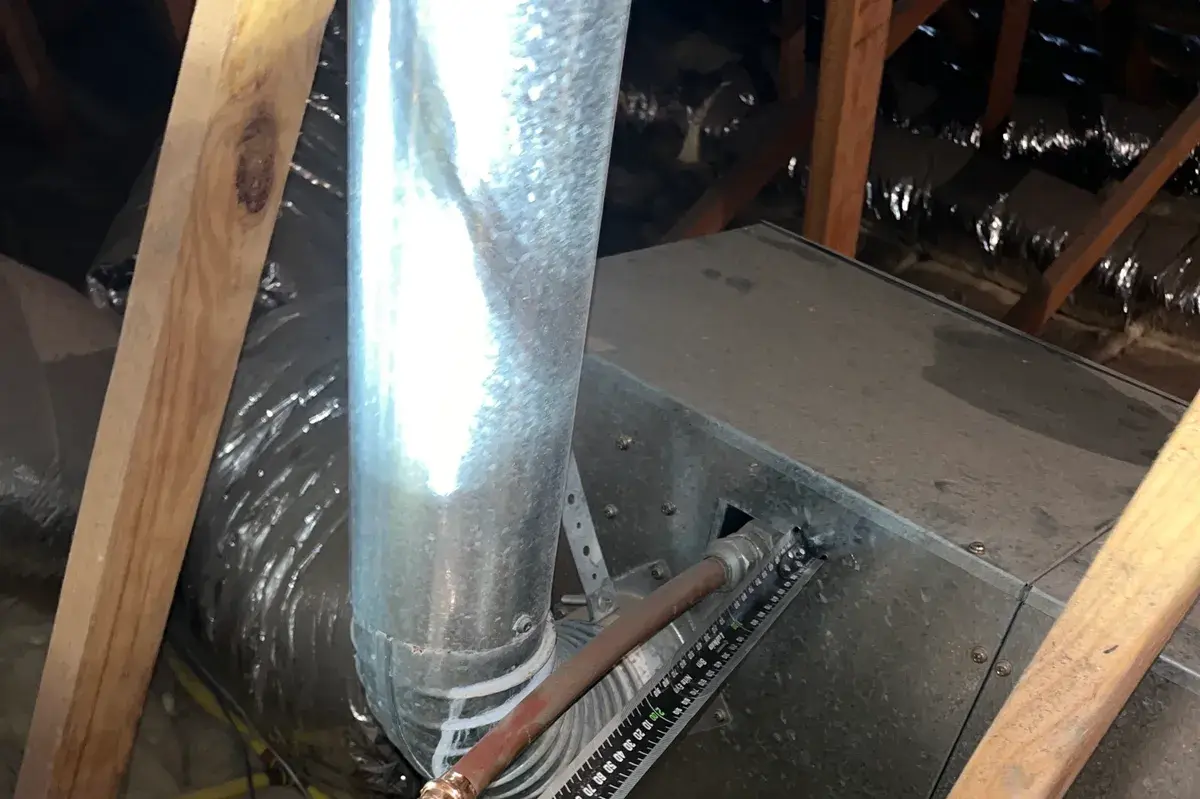Copper pipe in a roof space with a tape measure laid beside it