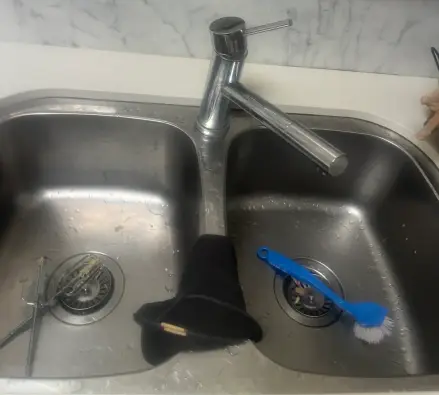 Double stainless steel sink with a chrome mixer tap and marble splashback