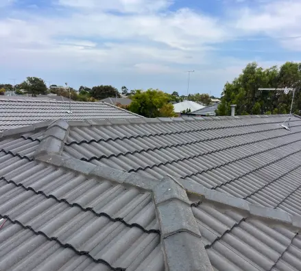Grey concrete tiled roof with ridge and hip capping