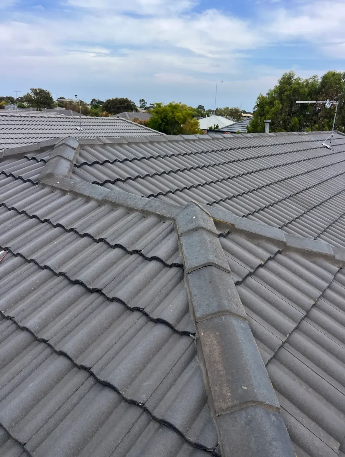 Grey concrete tiled roof with ridge and hip capping