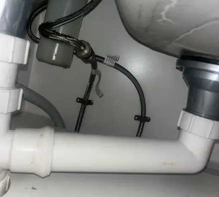 Pipework and traps under a sink in a cupboard