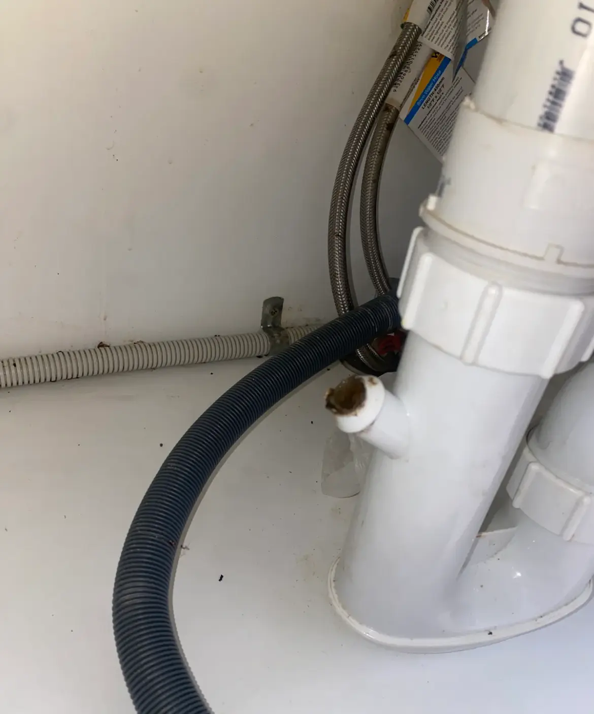 Plastic sink trap with a dishwasher spigot and dark drain hose