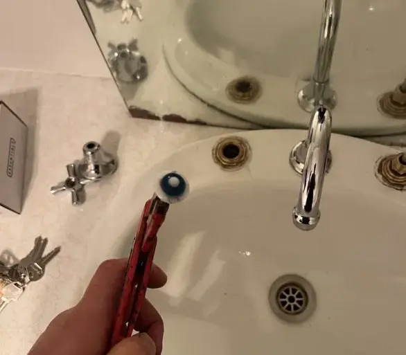 Plumber replacing a basin tap washer