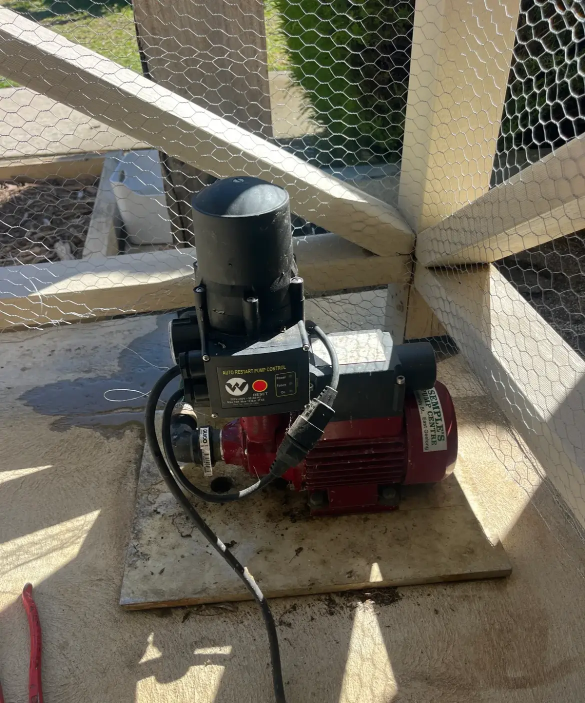 Red water pump with an automatic restart controller on a tile base