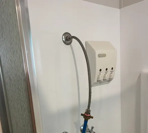 Shower recess with a pressure test hose connected to the outlet