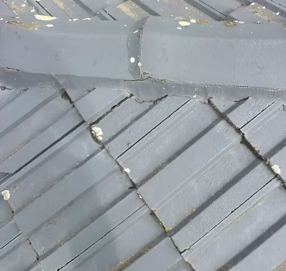 Tiled roof ridge capping with cracked pointing along the join