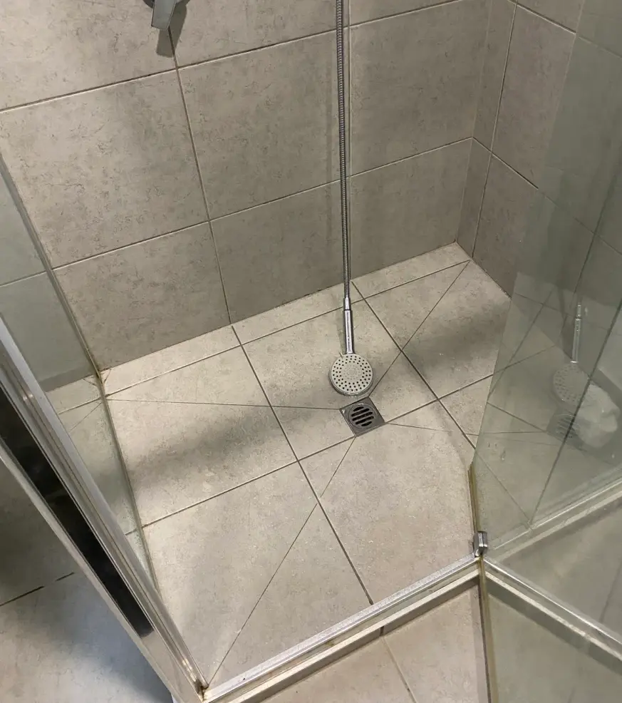 Tiled shower recess with a floor drain and a wall mixer