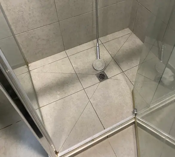 Tiled shower recess with a floor drain and a wall mixer