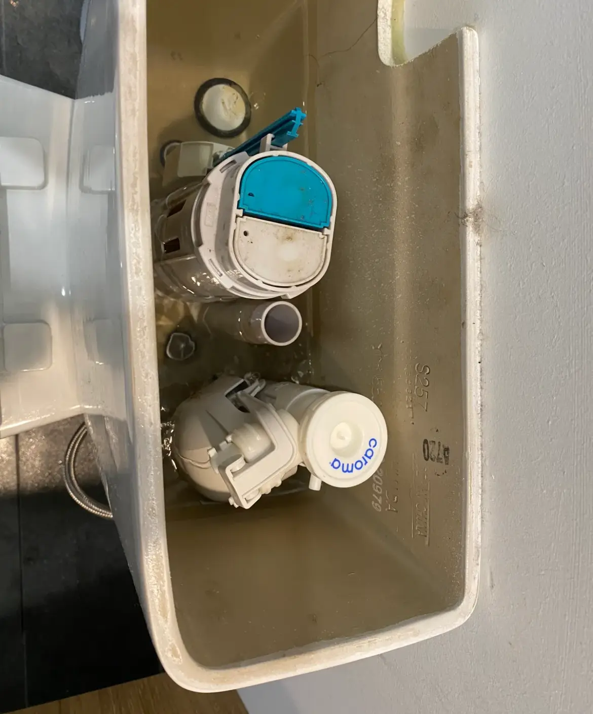 Toilet cistern with the lid removed showing the inlet and flush valve