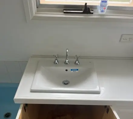 White ceramic drop-in sink with a three-hole tap set